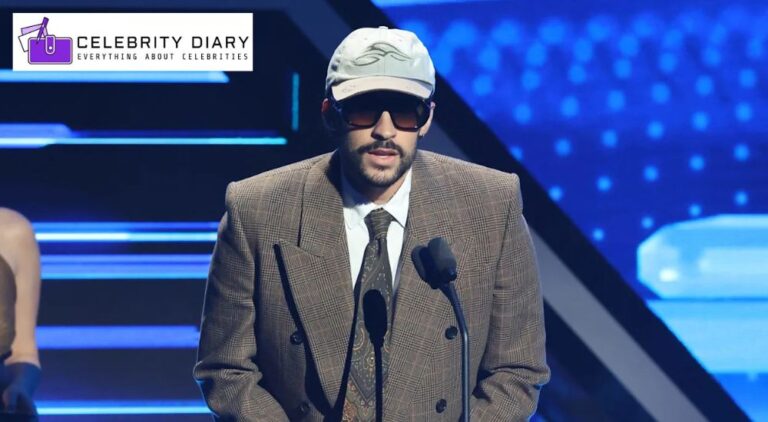 Bad Bunny speaking at the Latin Billboard Music Awards 2025 in a checked suit, sunglasses, and cap.